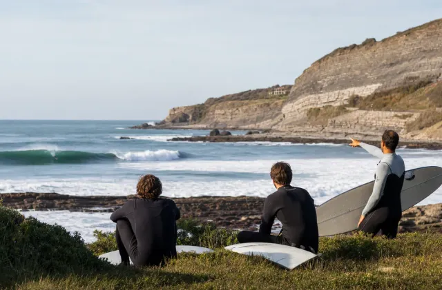 Surfeurs observant Parliamentia depuis les falaises de Bidart avant une vague plus avancée.