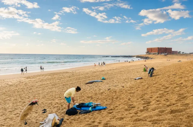 Plage ensoleillée de Capbreton avec des planches de surf débutant sur le sable près de Santocha.